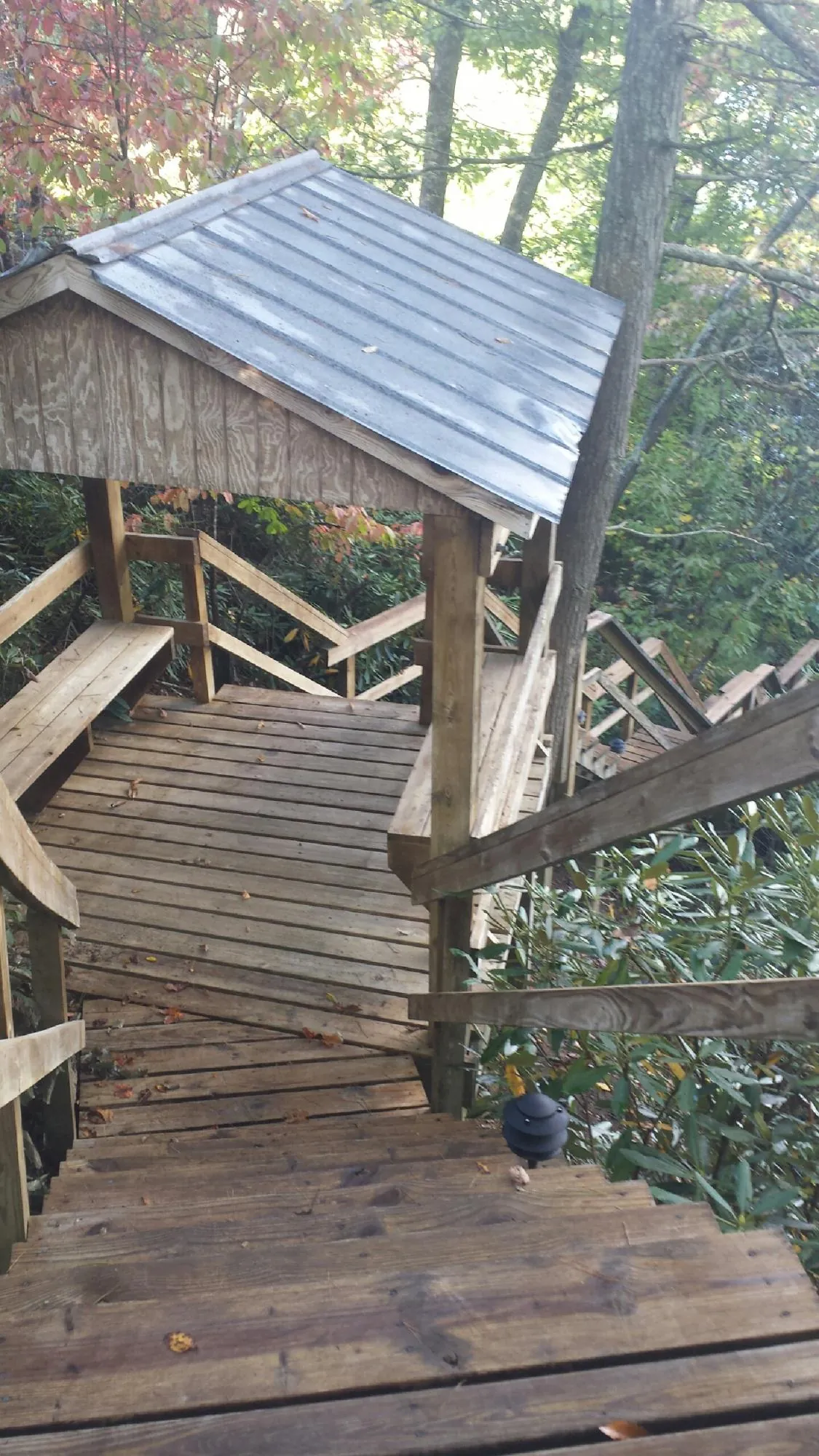 Metal roofed shelter over wooden steps on a wooded walkway — Skylight Repair & Installation work by our crew in Chippewa Lake