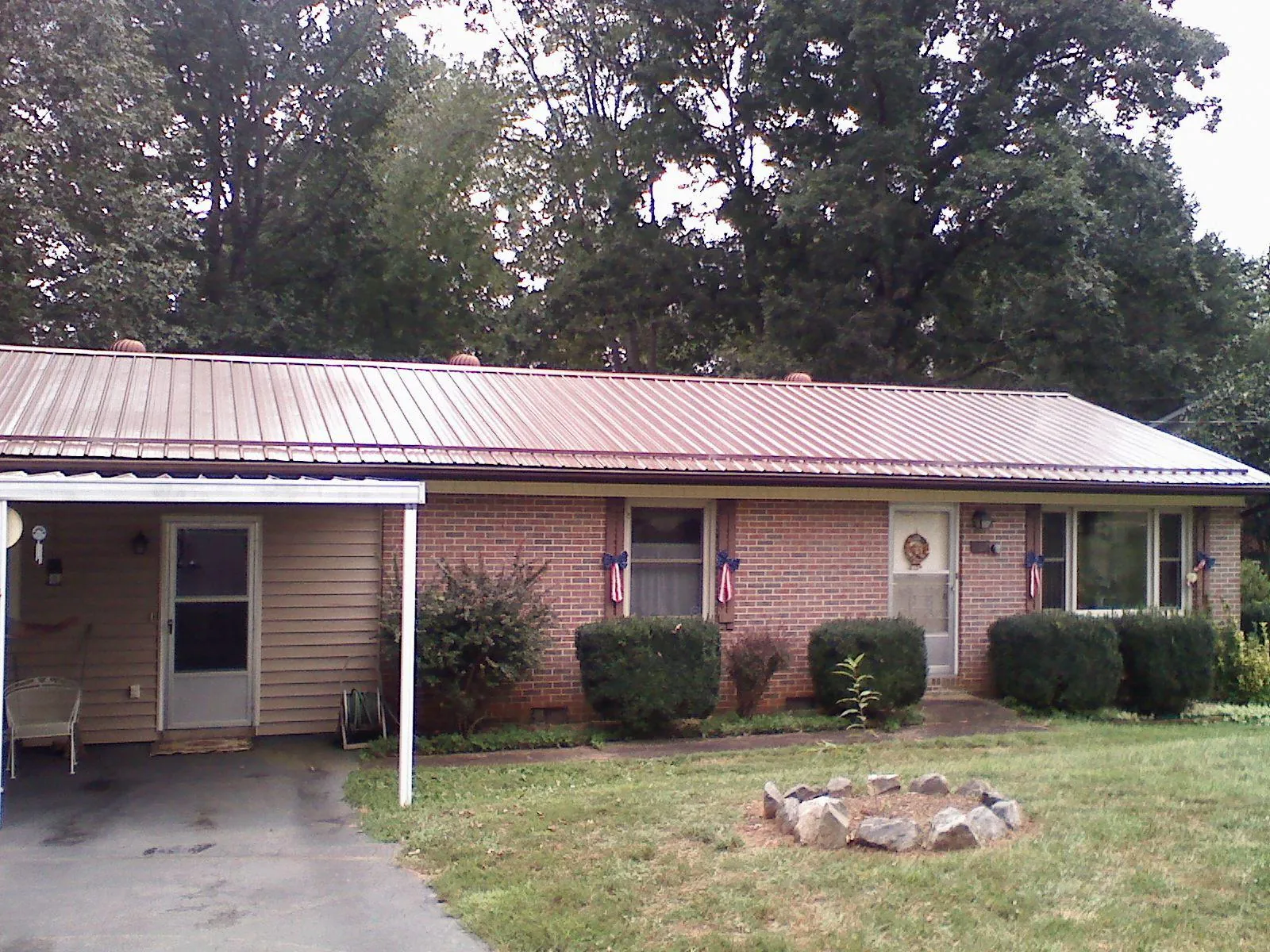 Bronze metal roof and carport on a brick ranch home — Roof Repair work by our crew in Chippewa Lake