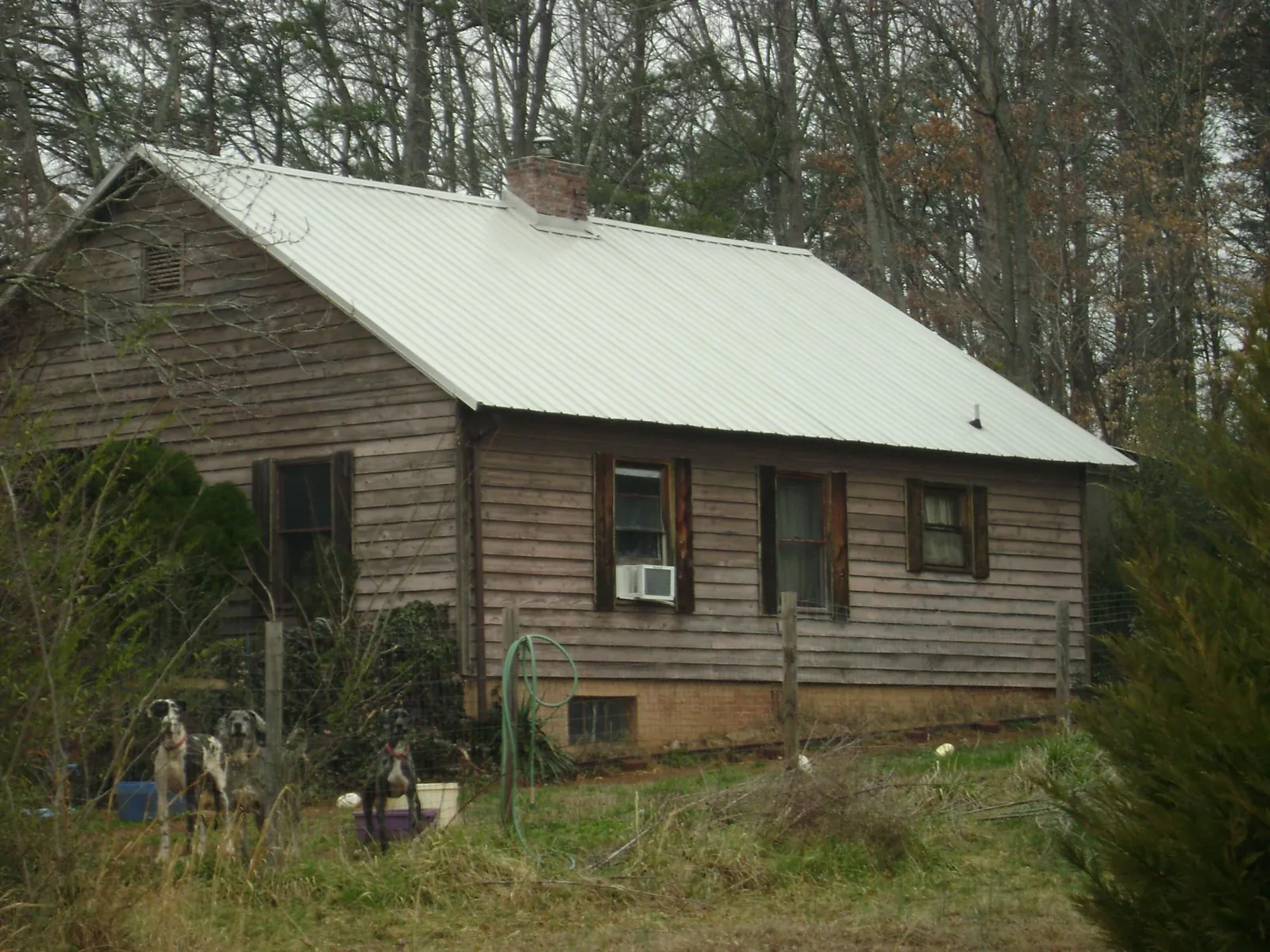 White metal roof on an old wood sided farmhouse, from a Metal Roof Installation job in Chippewa Lake